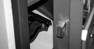 Open metal safe with gun inside