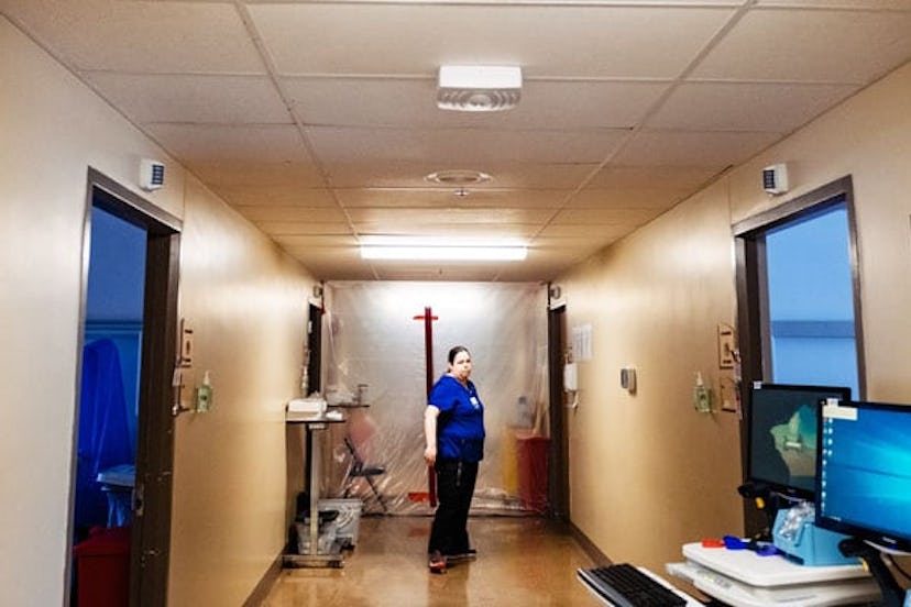 A hospital employee is seen next to a sealed space for nursing staff to don necessary equipment for ...