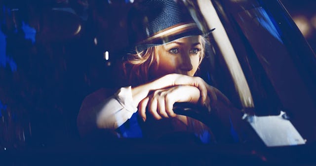 Woman with hat driving blue car