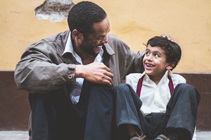 father and son sitting on curb