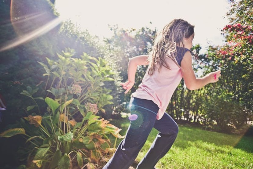 A young girl running in the yard.