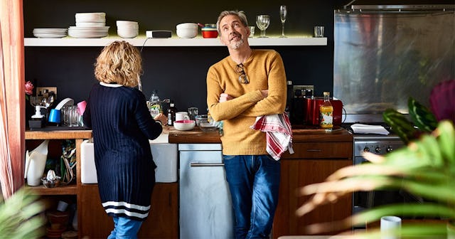 man looking up with arms folded with wife