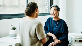 Smiling senior businesswoman in discussion with client in office conference room