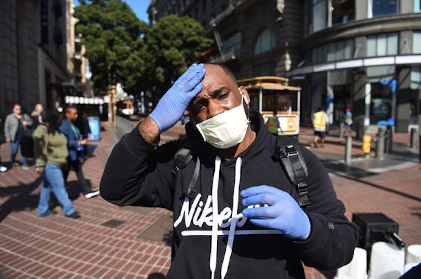 Cameron Nightingale adjusts his mask and gloves, a precaution to protect himself from coronavirus, w...