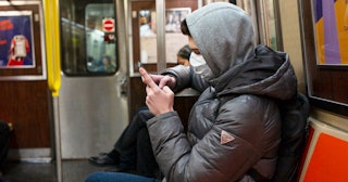 A man riding the subway wears a medical facemark out of concern over the Coronavirus in the Brooklyn...
