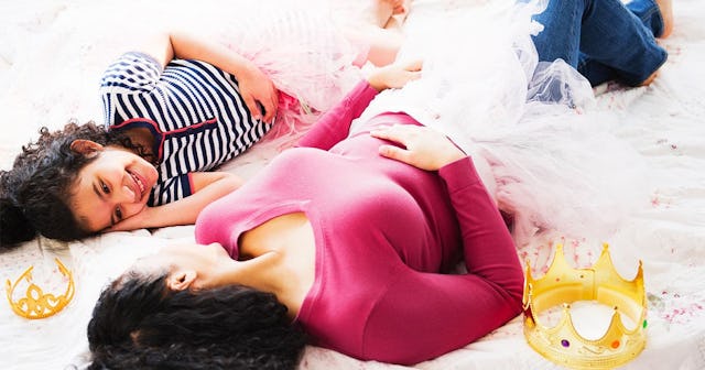 Mother and daughter in costumes laying on floor