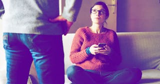 Cropped shot of man in front of womnan on sofa with smartphone