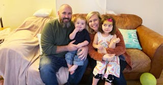 Family sitting on couch posing for photo