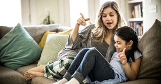 Mother and daughter using tablet on couch