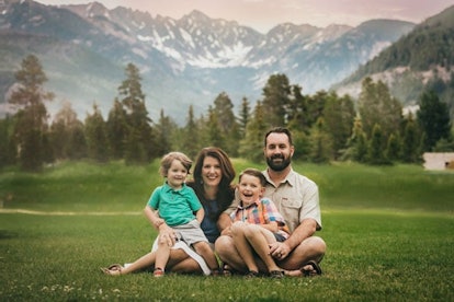 family posing for photo in front of mountains