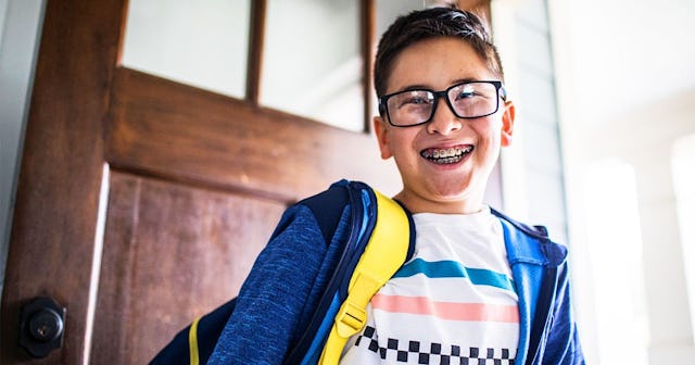 School age boy smiling and leaving for school