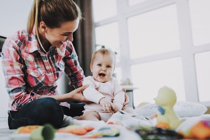 Mother Sits with Child on Floor and Holding Doll