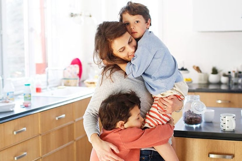 A mom hugging her sons in the kitchen