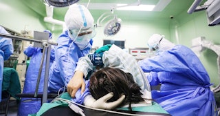 This photo taken on March 7, 2020 shows a doctor comforting a pregnant woman, infected by the COVID-...