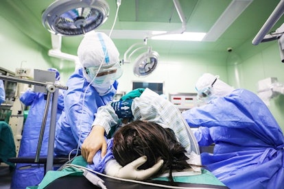 This photo taken on March 7, 2020 shows a doctor comforting a pregnant woman, infected by the COVID-...