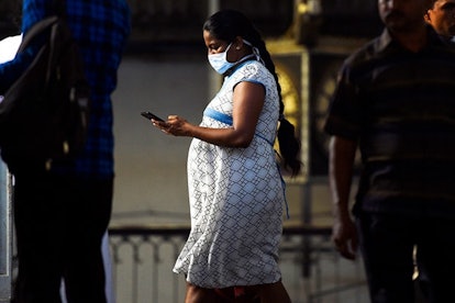 A preganant passenger wears a facemask at Fort railway station during a public holiday declared by t...