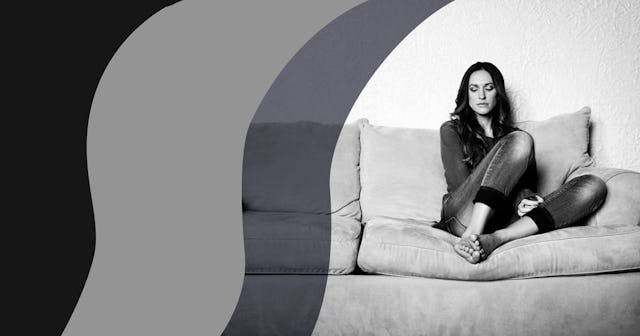 Upset woman sitting on sofa at home