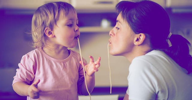 Mother and child eating spaghetti together