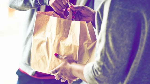The Importance Of Supporting Small Businesses Right Now: Close up of woman receiving take away food ...