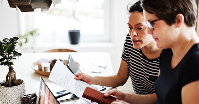 Lesbian couple discussing over financial bills while using laptop at table