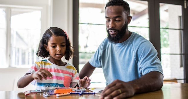 father and daughter working on science project at home