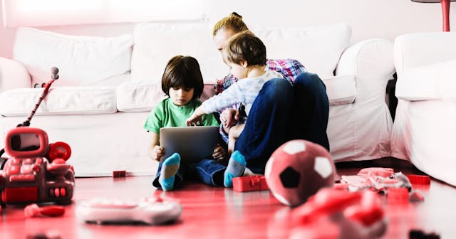 Mother with 2 kids using a digital tablet