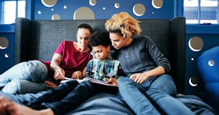 couple guiding a boy in doing his homework.