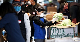 Volunteers pack boxes full of food at the San Francisco-Marin Food Bank on April 18, 2020 in San Raf...