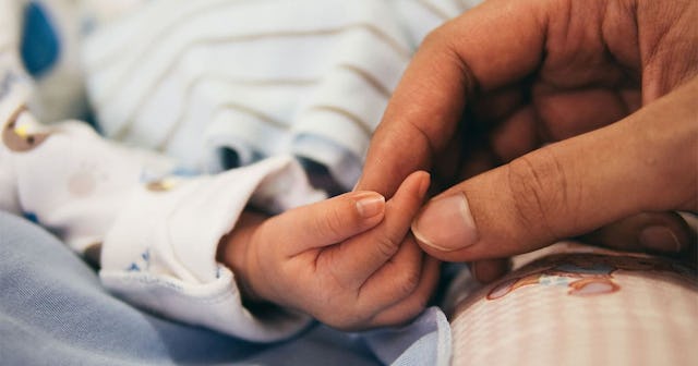 mom holding baby's hands