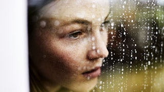 Close-up of pensive woman looking out of window
