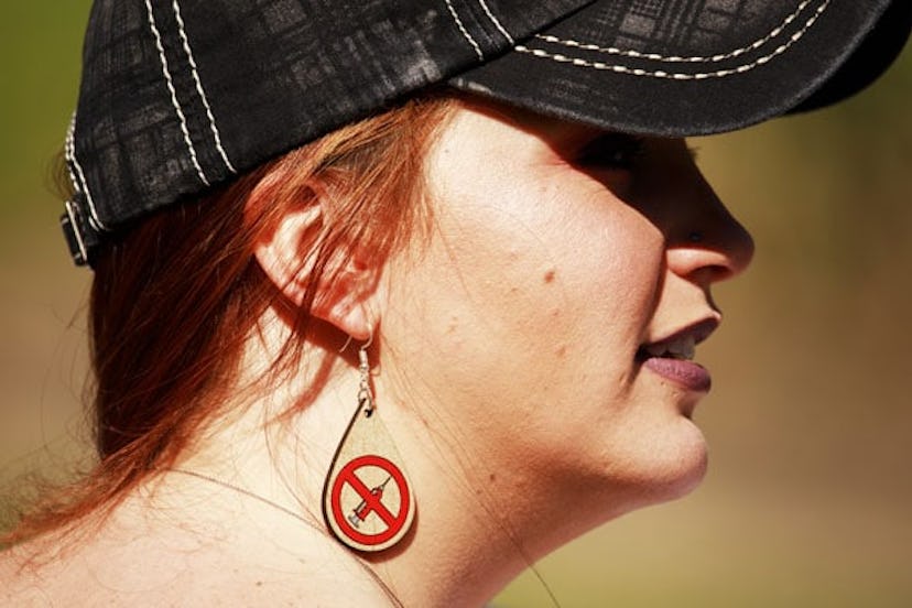 Anti vaxxer wearing anti vaccination earrings takes part during the protest. Protesters gather outsi...