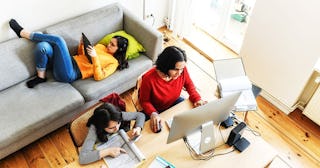 woman with two daughters working at home office in living room