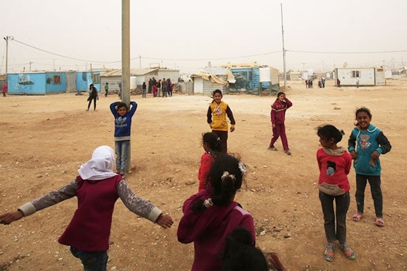 Syrian refugee children play during a sand storm at the Zaatari refugee camp on November 13, 2017.