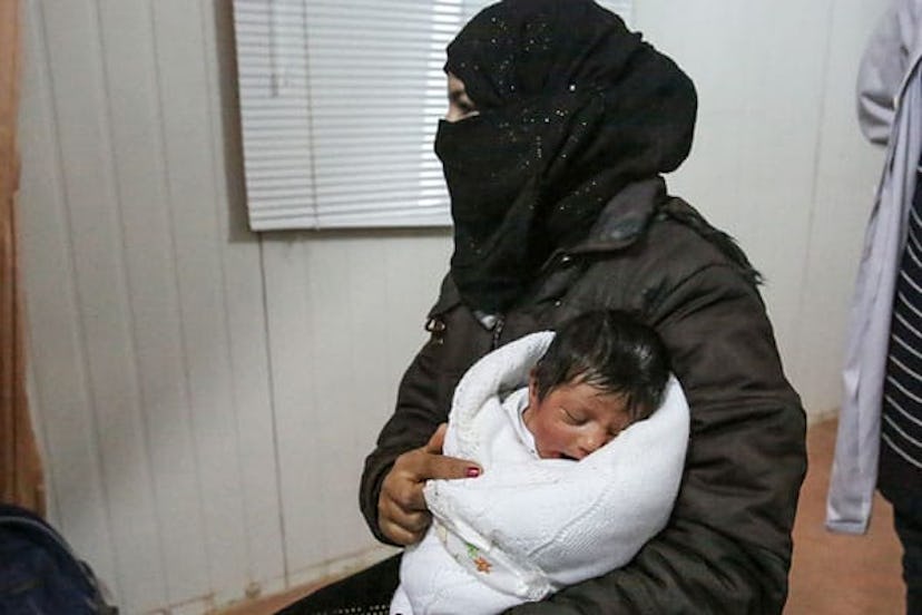 16-year-old girl cradles her newborn baby at the UNFPA-run maternity centre in Zaatari Syrian refuge...