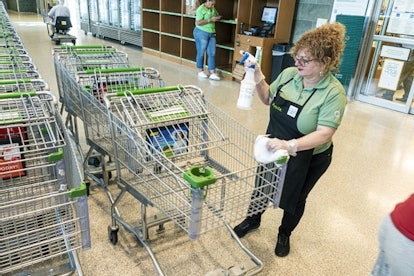 Florida, Worker disinfecting and cleaning shopping carts at Publix grocery store.