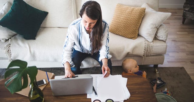 High angle view of female entrepreneur concentrating on work while daughter playing at home office