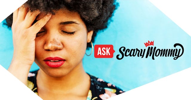 woman, hand on forehead, blue wall in the background
