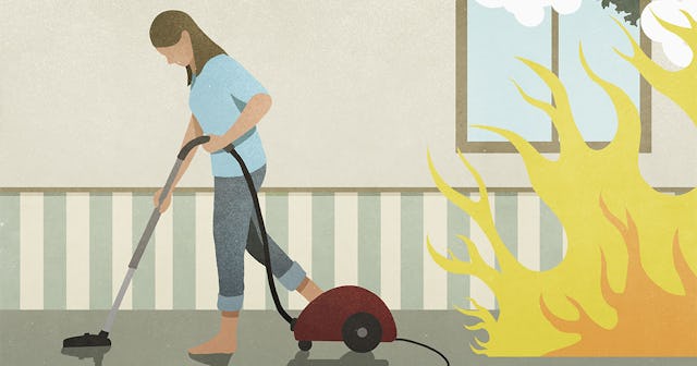 Flames and smoke behind oblivious woman vacuuming carpet