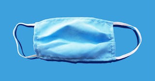 Blue medical face mask to avoid contagious diseases pattern on blue background