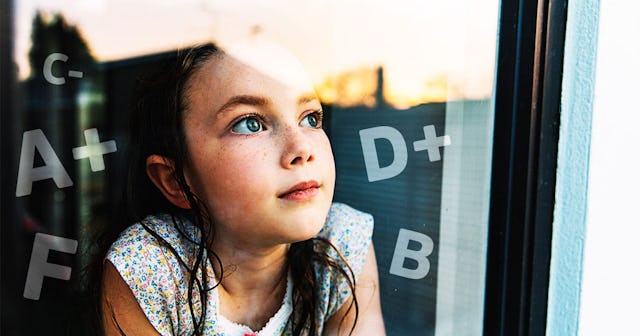 Young girl looking through window at sunset