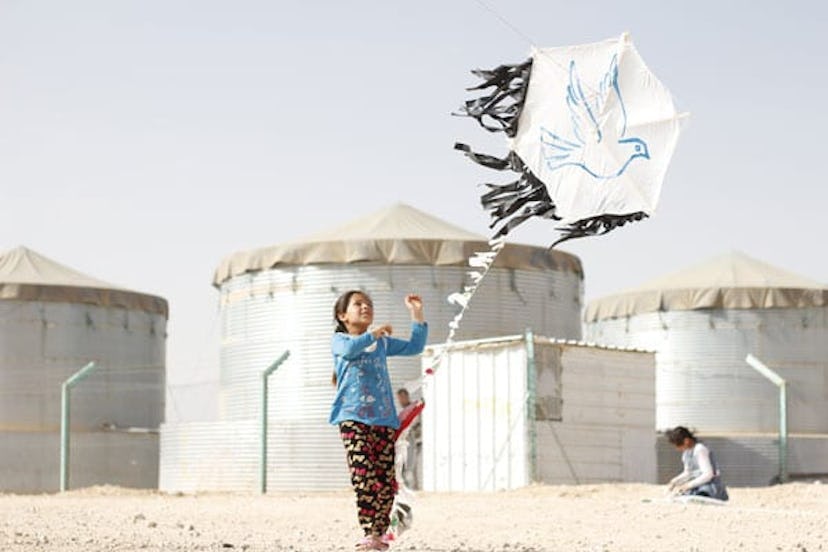 A young girl flies a kite in Za'atari refugee camp in Jordan.