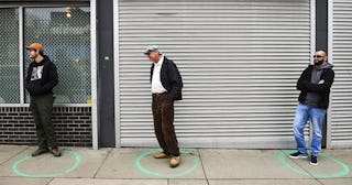 People stand in freshly painted circles, six-feet-apart, as they wait in a two-hour line to buy mari...