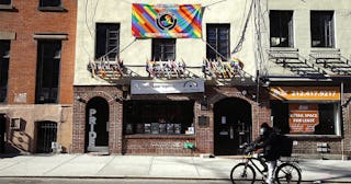 A man rides past The Stonewall Inn on Christopher Street as New York City attempts to slow down the ...