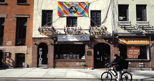 A man rides past The Stonewall Inn on Christopher Street as New York City attempts to slow down the ...