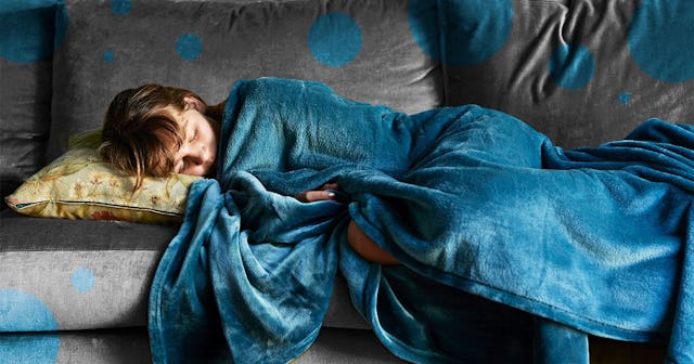 Girl sleeping on couch, wrapped in blue blanket