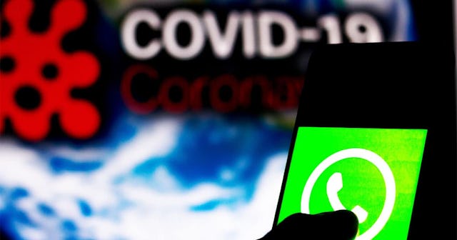 WhatsApp logo seen displayed on a smartphone with a computer model of the COVID-19 coronavirus in th...