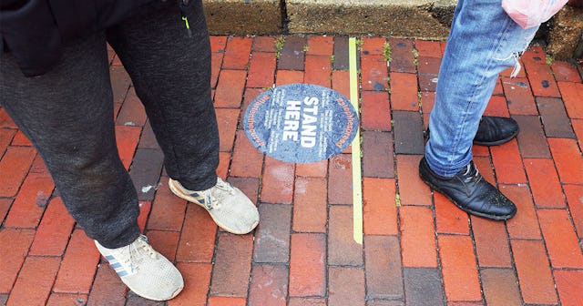 A marker for social distancing guideline is seen on the pavement outside of a tavern in the normally...