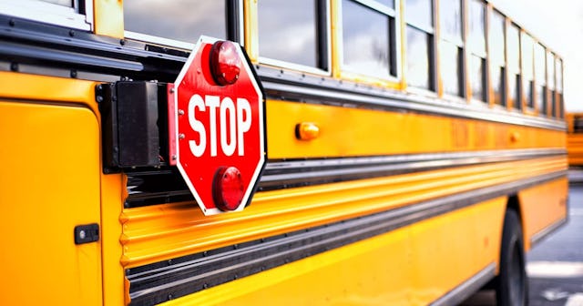 Close up of a yellow school bus with the red STOP sign