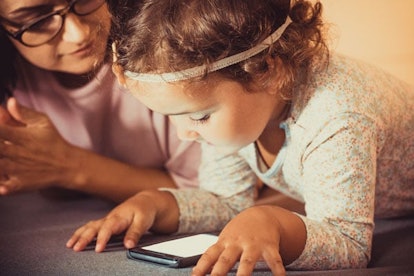 Little girl using smart phone while being at home