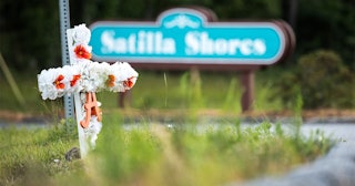 A cross with flowers and a letter "A" sits at the entrance to the Satilla Shores neighborhood where ...